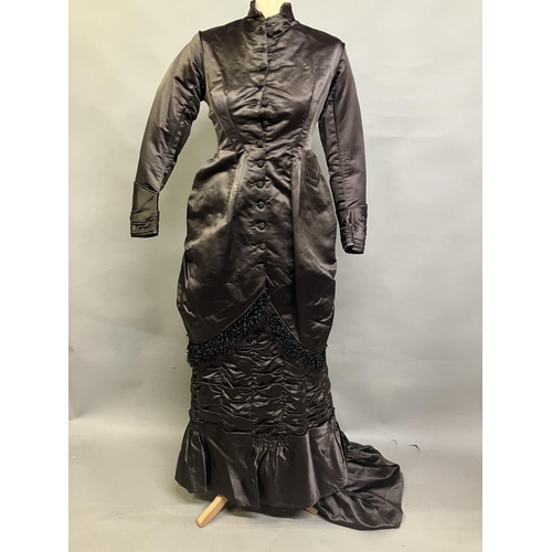 343 - A chestnut brown silk two-piece costume, c 1880’s, the tailored long-line jacket with covered button... 