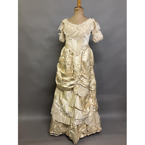 355 - An elaborate 1880’s wedding or evening gown, skirt with integral boned bodice, a heavy honey silk, r... 