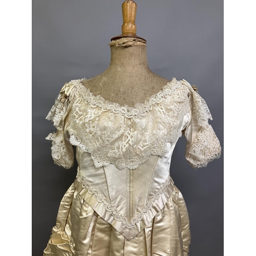 355 - An elaborate 1880’s wedding or evening gown, skirt with integral boned bodice, a heavy honey silk, r... 