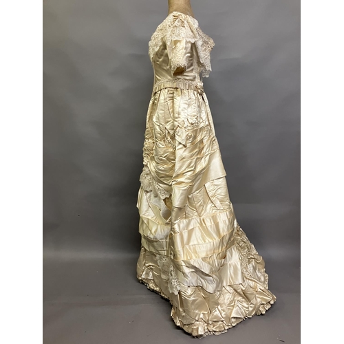 355 - An elaborate 1880’s wedding or evening gown, skirt with integral boned bodice, a heavy honey silk, r... 