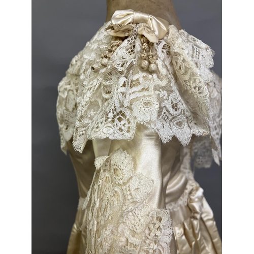 355 - An elaborate 1880’s wedding or evening gown, skirt with integral boned bodice, a heavy honey silk, r... 