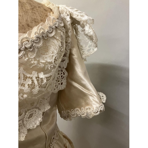 355 - An elaborate 1880’s wedding or evening gown, skirt with integral boned bodice, a heavy honey silk, r... 