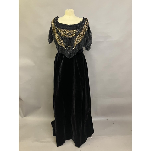 358 - A mid-19th century black velvet evening two piece, the full skirt plain, the bodice rear-lacing, wit... 