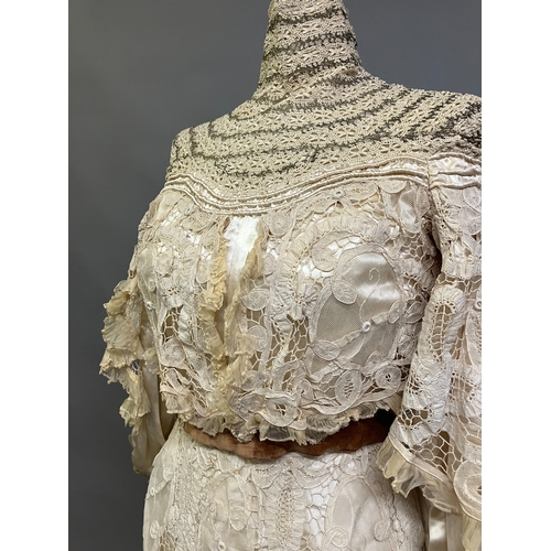 322 - An Edwardian tapelace wedding ensemble, the high-necked bodice in ivory silk satin, trimmed with cre... 