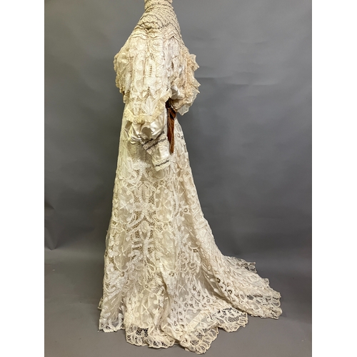 322 - An Edwardian tapelace wedding ensemble, the high-necked bodice in ivory silk satin, trimmed with cre... 