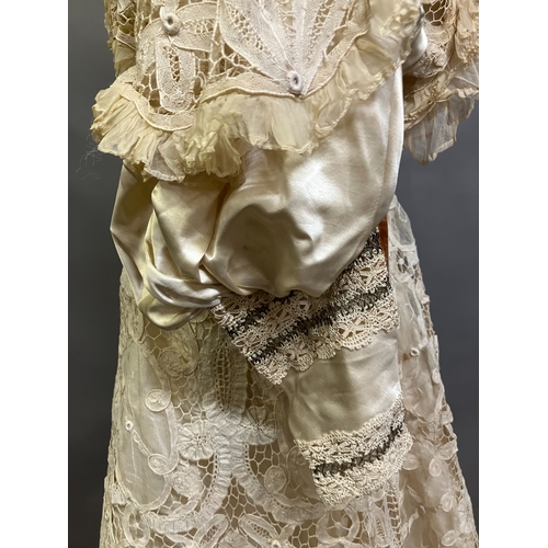 322 - An Edwardian tapelace wedding ensemble, the high-necked bodice in ivory silk satin, trimmed with cre... 