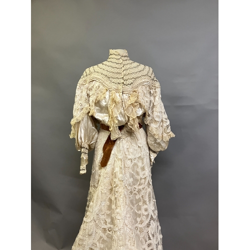 322 - An Edwardian tapelace wedding ensemble, the high-necked bodice in ivory silk satin, trimmed with cre... 