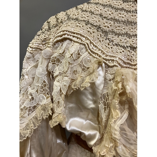 322 - An Edwardian tapelace wedding ensemble, the high-necked bodice in ivory silk satin, trimmed with cre... 