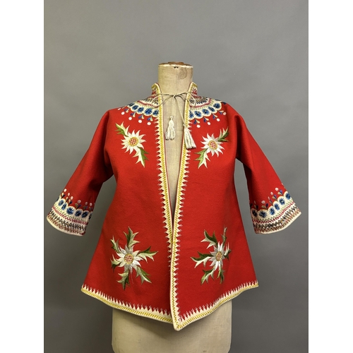 184 - A Child’s folk dress coat, in red wool with cream cuffs, seam and collar, heavily embroidered with f... 