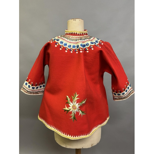 184 - A Child’s folk dress coat, in red wool with cream cuffs, seam and collar, heavily embroidered with f... 