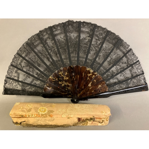 52B - A 19th century tortoiseshell fan mounted with a black Chantilly bobbin lace leaf, the design of rose... 