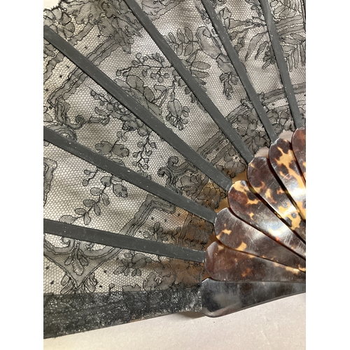 52B - A 19th century tortoiseshell fan mounted with a black Chantilly bobbin lace leaf, the design of rose... 