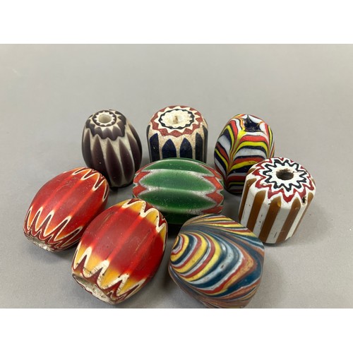 191 - Trade beads: six large chevron beads and two others, in varying colours, average length approx. 3.5 ... 