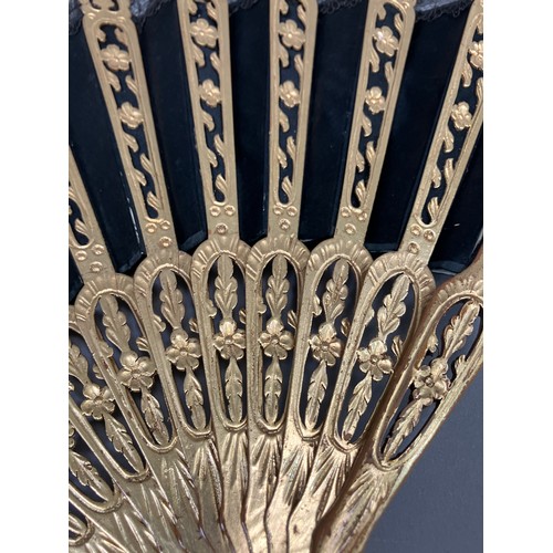 17 - A wood fan, the monture carved and pierced, painted gold, c 1870’s, the black silk satin leaf with b... 