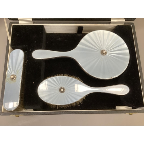 373 - A silver and blue enamel three piece dressing table set, in fitted case, comprising hand mirror, hai... 