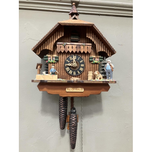 325 - A Black Forest style cuckoo clock with swinging pendulum and weights having two figures , goats and ... 