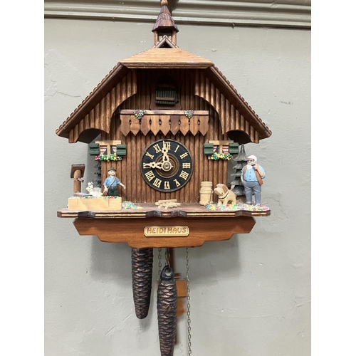 325 - A Black Forest style cuckoo clock with swinging pendulum and weights having two figures , goats and ... 