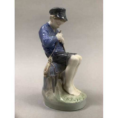 37 - A Royal Copenhagen figure of a Dutch boy whittling a stick, 18.5cm high