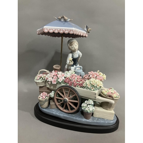 46 - A Lladro figure group, Flowers of the Season, of a girl with flower cart under an umbrella, 30cm hig... 