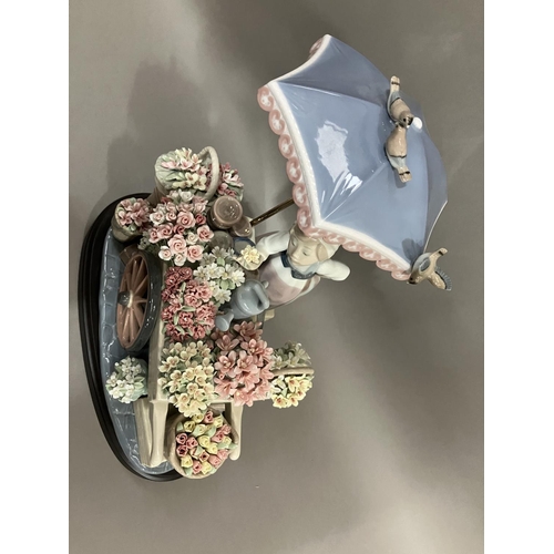 46 - A Lladro figure group, Flowers of the Season, of a girl with flower cart under an umbrella, 30cm hig... 