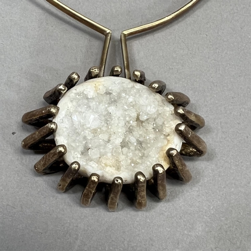 458 - A silver quartz geode pendant c1965, the oval convex crystaline stone claw set pendant from a torq t... 