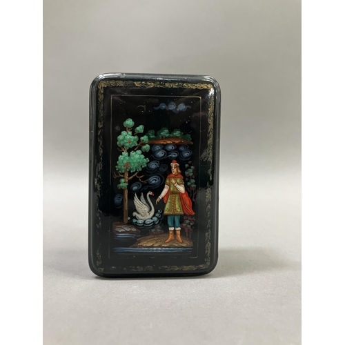 38 - A Russian black lacquered trinket box, rectangular, the cover painted with a figure and swan, 8.5cm ... 