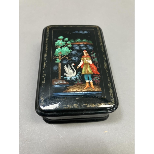 38 - A Russian black lacquered trinket box, rectangular, the cover painted with a figure and swan, 8.5cm ... 