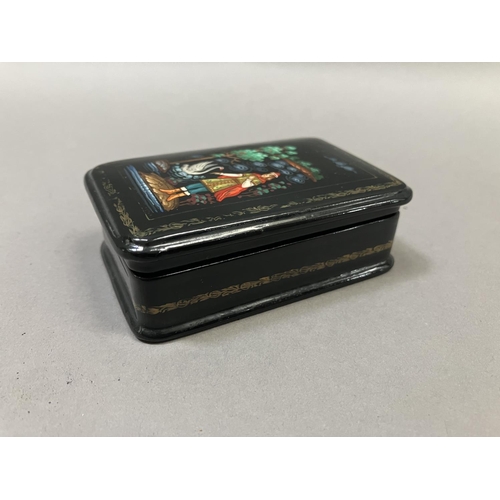 38 - A Russian black lacquered trinket box, rectangular, the cover painted with a figure and swan, 8.5cm ... 