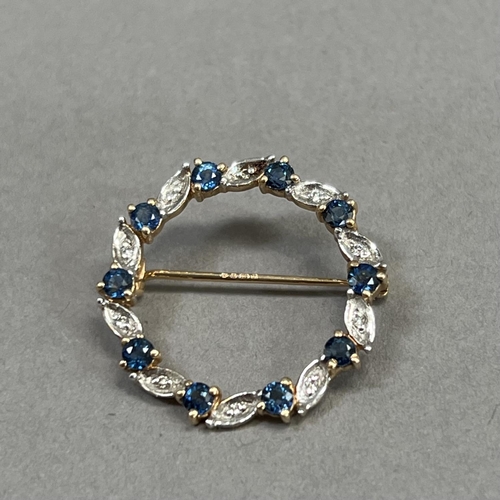 435 - A sapphire and diamond wreath brooch in 9ct gold claw and grain set with small eight cut diamonds an... 