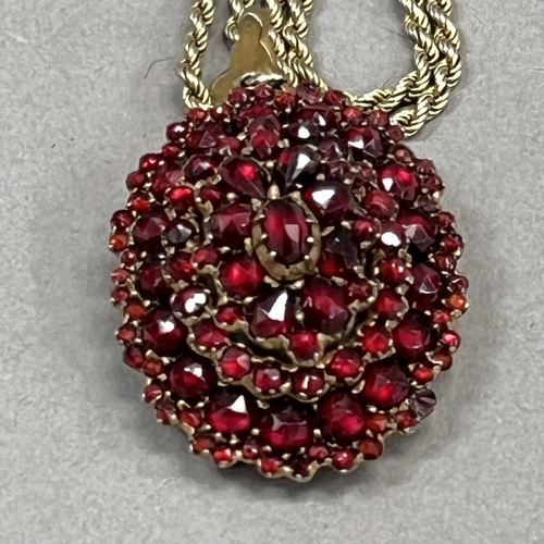 446 - A 19th century Bohemian garnet cluster pendant/locket of oval outline all over set to the front and ... 