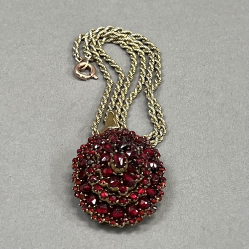 446 - A 19th century Bohemian garnet cluster pendant/locket of oval outline all over set to the front and ... 