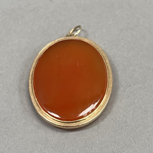 443 - A Cornelian pendant in 9ct gold, the oval double cabochon stone collet set in 9ct gold, approximate ... 