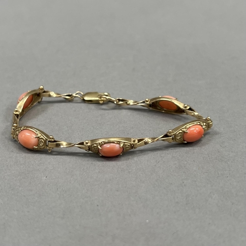 426 - A coral bracelet in 9ct gold, each foliate patterned tonneau link claw set with an oval cabochon sep... 