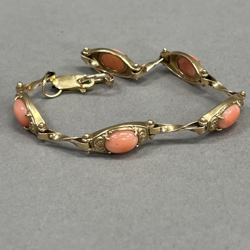 426 - A coral bracelet in 9ct gold, each foliate patterned tonneau link claw set with an oval cabochon sep... 