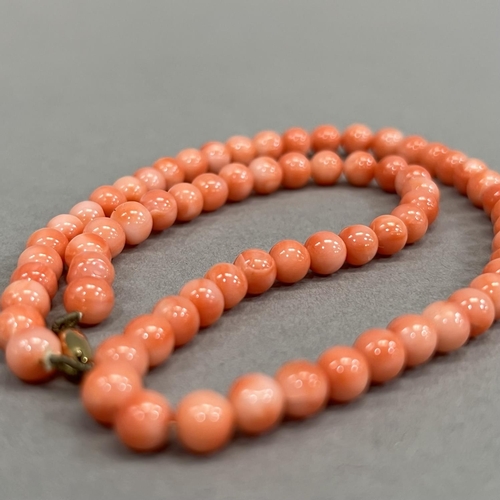 465 - A necklace of spherical coral beads, each approximate 6mm diameter fastened with 9ct gold snap, appr... 