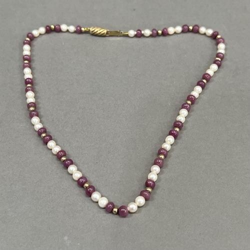 462 - A seed pearl and ruby bead necklace, the approximate 4.5mm diameter spherical ruby beads interspaced... 