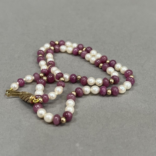 462 - A seed pearl and ruby bead necklace, the approximate 4.5mm diameter spherical ruby beads interspaced... 