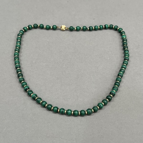 471 - A Malachite bead necklace, each 6mm spherical bead interspaced with a small 9ct gold bead, fastened ... 