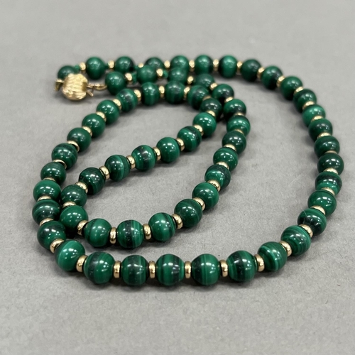 471 - A Malachite bead necklace, each 6mm spherical bead interspaced with a small 9ct gold bead, fastened ... 