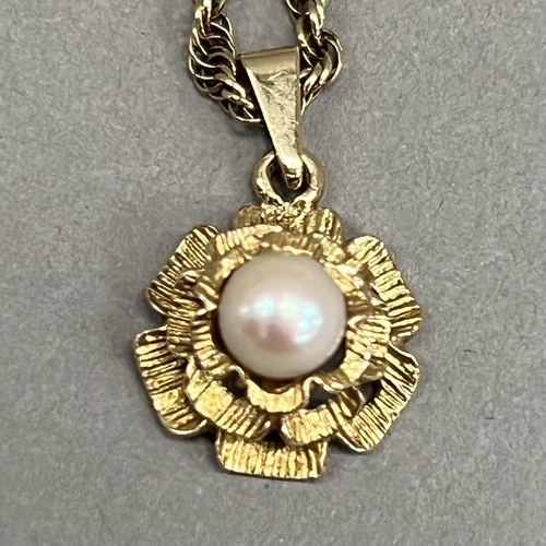 427 - A cultured pearl pendant in 9ct gold, the 5.5mm pearl set to the centre of a tiered textured flower ... 