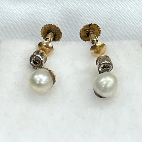 448 - A pair of cultured pearl and diamond earrings, c1920, in 9ct gold, each 5.5mm pearl pendant from a c... 