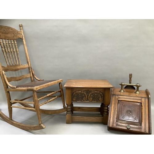 125 - An oak rocking chair with bobbin supports and carved crest together with an oak stool with carved fr... 