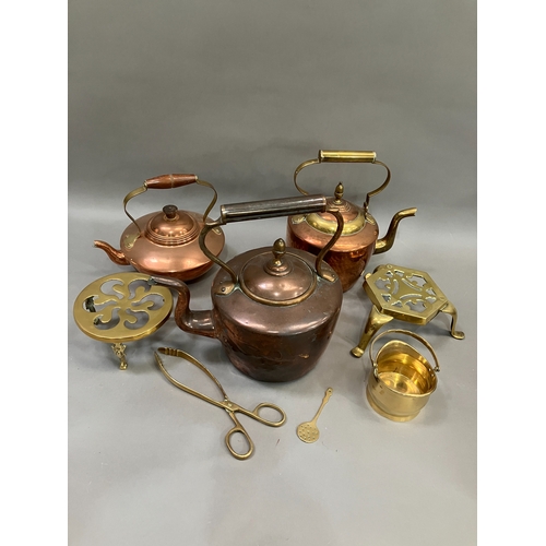 100 - Three copper and brass kettles, two brass trivets together with further brass ware