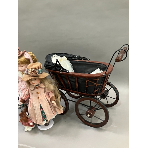 354 - Two modern ceramic dolls with jointed bodies and Victorian style pram together with another smaller ... 