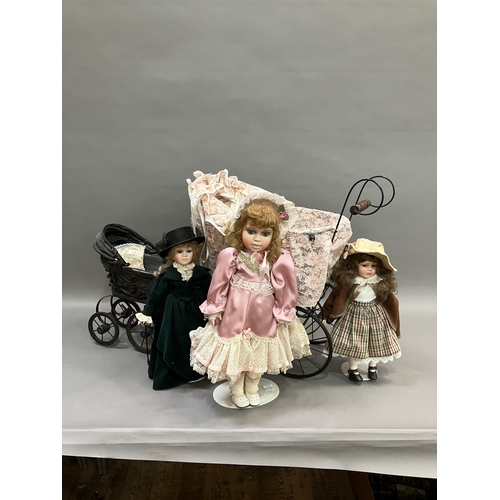 353 - Three modern dolls with porcelain heads and jointed bodies in a Victorian style pram with lace and a... 