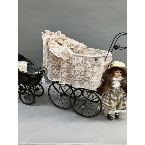 353 - Three modern dolls with porcelain heads and jointed bodies in a Victorian style pram with lace and a... 