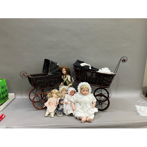 351 - A collection of six modern porcelain dolls in costume, together with two Victorian style prams