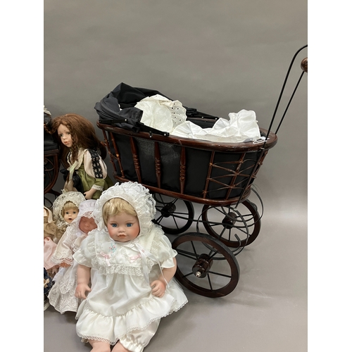 351 - A collection of six modern porcelain dolls in costume, together with two Victorian style prams