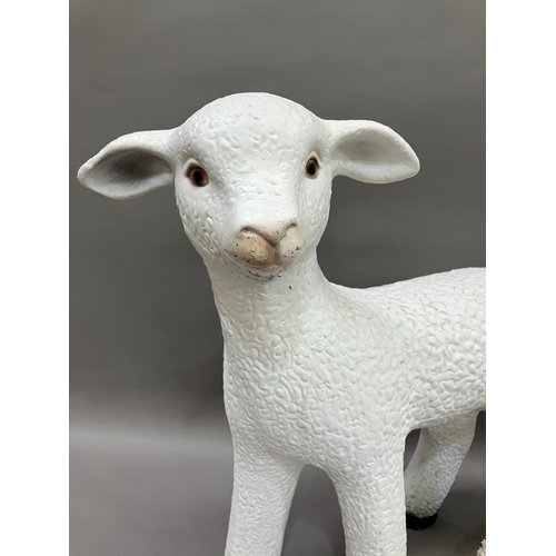 129 - A ceramic figure of a lamb together with a smaller composite example