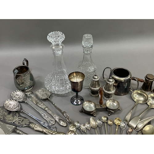 307 - A collection of silver plated ware and glass ware comprising two decanters with stoppers, salt and p... 